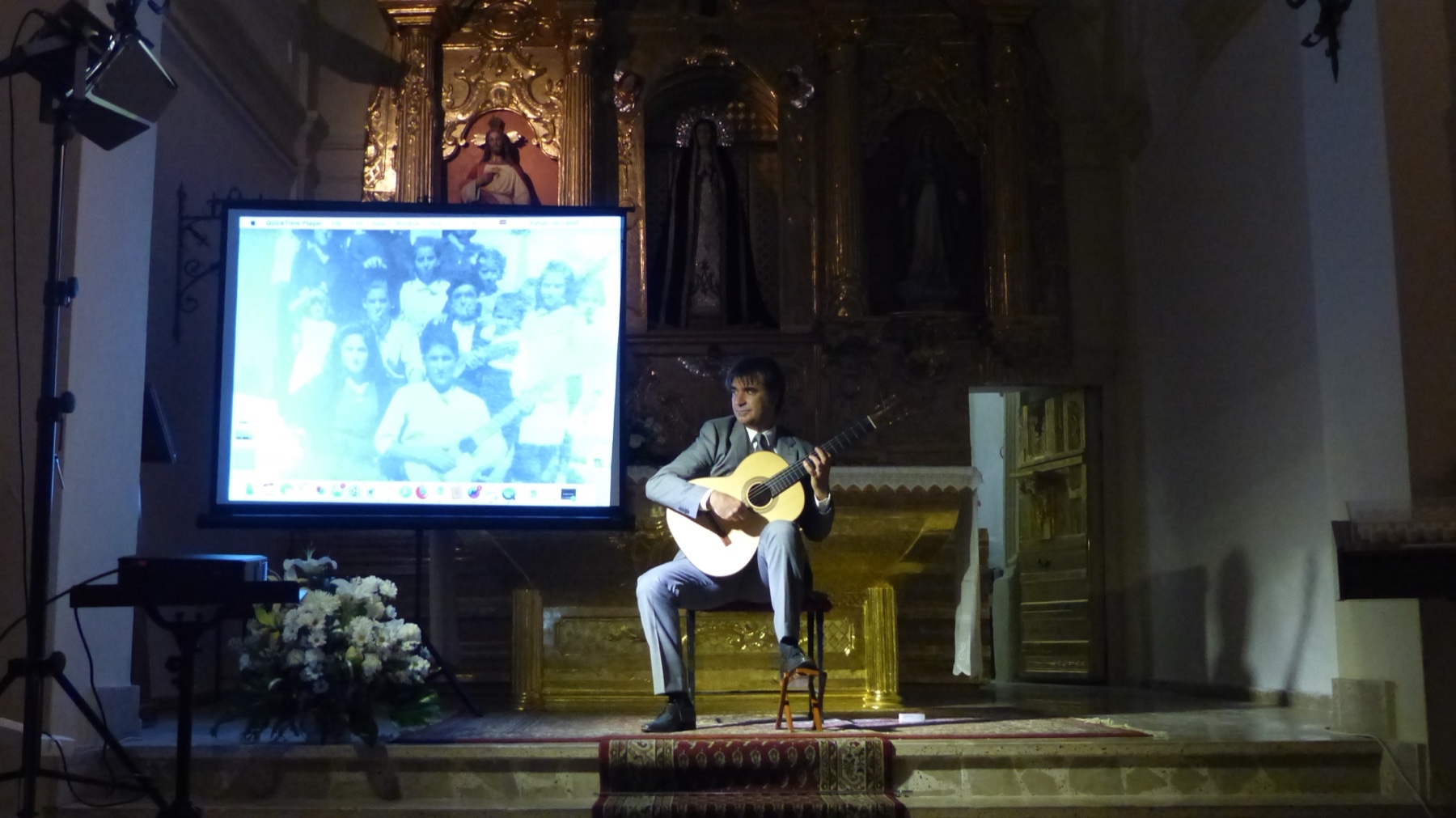 Rafael Serrallet performing guitar beside a projection screen