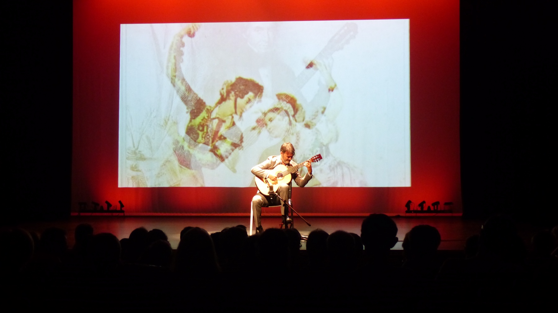 Rafael Serrallet performing a multimedia guitar concert with projected imagery